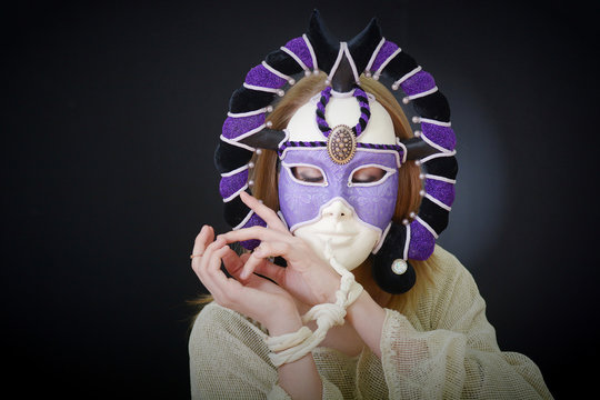 actress in a theatrical mask with her hands tied