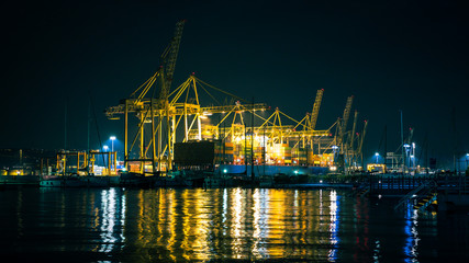 Fototapeta na wymiar Unloading big cargo ship with lot of cranes at the dock