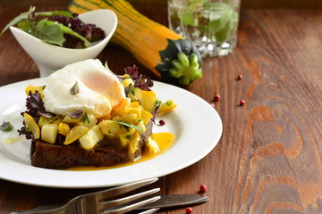 Healthy breakfast - toast with roasted yellow zucchini, pesto and poached egg, copy space