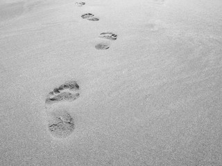 close up footprint on sand at the beach background in black and white color
