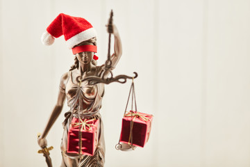 Justitia zu Weihnachten mit Geschenken auf Waage