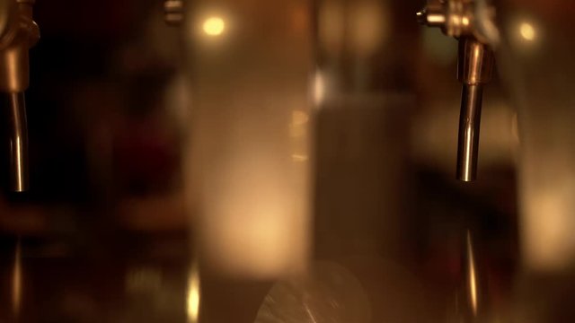 Close up of a beer tap in an Italian bar. Table with glasses and blurred bar background. Locked down real time establishing shot