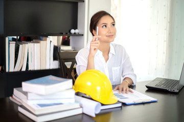 Female engineers are thinking to create new jobs and are smiling and working happy.