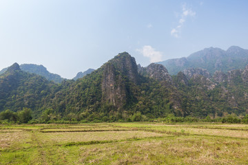 Beautiful view of a field and karst limestone mountains near Vang Vieng, Vientiane Province, Laos,...