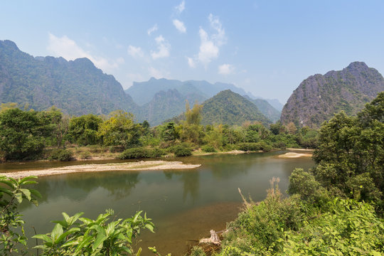 Beautiful view of the Nam Song River and karst limestone mountains near Vang Vieng, Vientiane Province, Laos, on a sunny day.