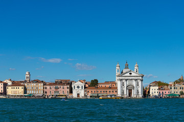Fototapeta na wymiar Horizontal view of Chiesa di Santa Maria del veni Rosario and Venizia architectures along riverside on Venize island, Italy 