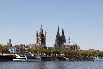 Fototapeta premium die basilika und der kölner dom vom rhein ufer köln deutschland fotografiert während einer Bootstour auf dem Rhein mit dem Weitwinkelobjektiv