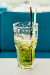 tall glass with cocktail is on t table