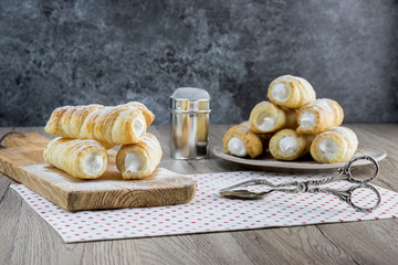puff pastry creme rolle with cream (traditional Czech dessert) with confectioner pliers - Powered by Adobe