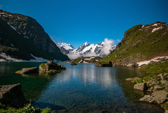 Swiss alps water reflection in Lac de Louvie - mountain lake above Val de Bagnes valley, Switzerland.