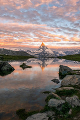 Obraz premium Morning shot of the golden Matterhorn (Monte Cervino, Mont Cervin) pyramid and blue Stellisee lake. Sunrise view of majestic mountain landscape in Switzerland.