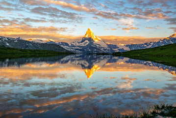 Morning shot of the golden Matterhorn (Monte Cervino, Mont Cervin) pyramid and  blue Stellisee lake. Sunrise view of majestic mountain landscape.