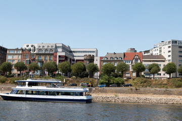Naklejka premium ein schiff vor imposanter skyline am rhein ufer in köln deutschland fotografiert während einer Bootstour auf dem Rhein mit dem Weitwinkelobjektiv