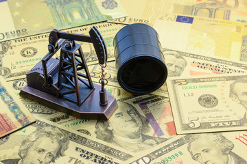 Petroleum, petrodollar and crude oil concept : Pump jack and a black barrel on US USD dollar notes,...