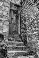 ancient wooden door with steps in black and white
