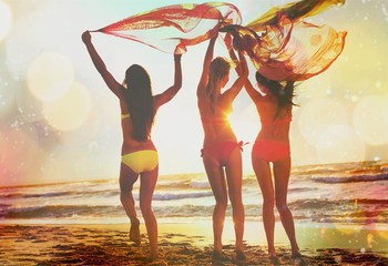 Portrait of three young women friends walking on the sea shore