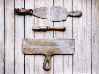 Kit of putty knives. Spatulas with the remaining mortar. Gastarbeiter or guest worker concept....