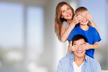 Naklejka na ściany i meble Beautiful smiling family sitting at sofa at home