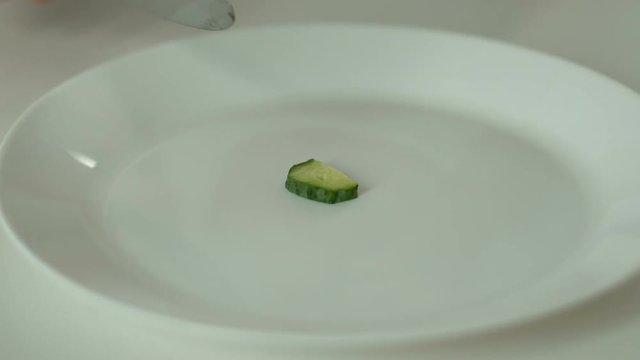 Person slicing cucumber, undereating and anorexia, strict self-restriction
