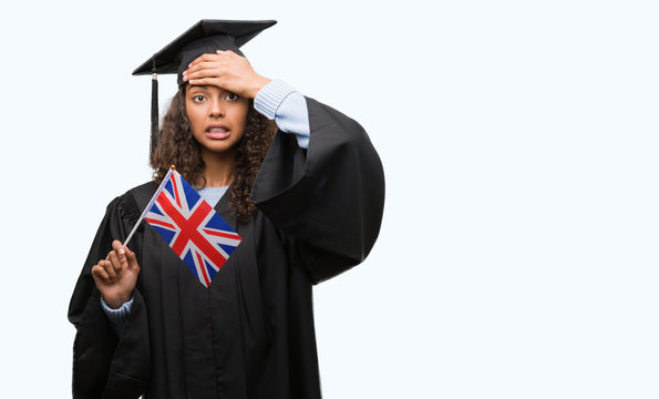 Young hispanic woman wearing graduation uniform holding flag of UK stressed with hand on head, shocked with shame and surprise face, angry and frustrated. Fear and upset for mistake.