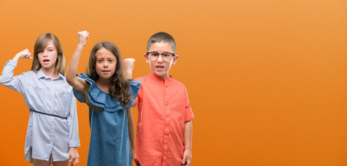 Group of boy and girls kids over orange background annoyed and frustrated shouting with anger, crazy and yelling with raised hand, anger concept