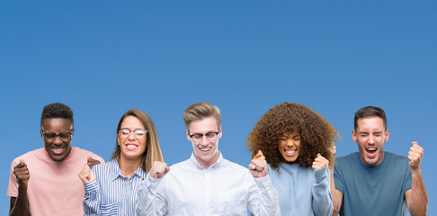 Composition of group of friends over blue blackground excited for success with arms raised...