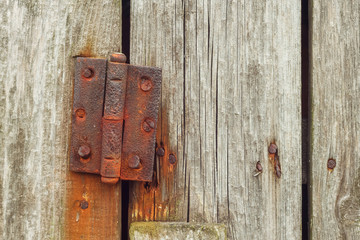 Rusty hinges on rotten doors. Old wooden boards. Background. Copy space