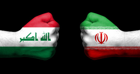 Flags of Iraq and Iran painted on two clenched fists facing each other on black background/Iraq -...
