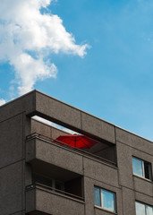 The red parasol on the balcony on the apartment block