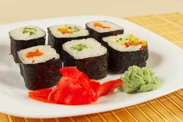 Sushi set with ginger and wasabi on a bamboo mat close up.