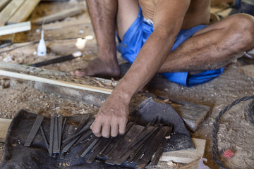 Details of an isolated hand reaching for chisels.