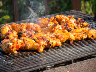 delicious hot chicken wings frying on grill