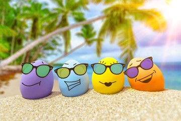 Funny eggs with sunglasses on exotic beach