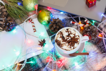 A cup of hot chocolate and marshmallows in Christmas decoration. New Year background.