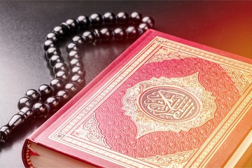 Islamic Book Koran with rosary on background