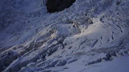 Wysokogórski alpejski lodowiec pokryty szczelinami z bliska. 