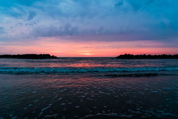 Morgendämmerung am Meer, der Horizont flankiert von zwei Felsen