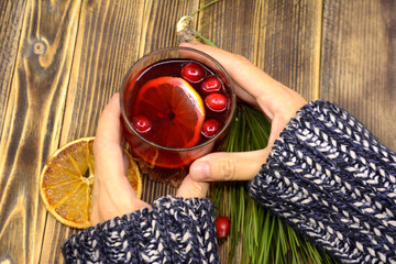 Hot winter or autumn cranberry drink in hand