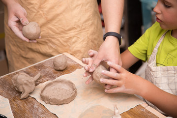 Pottery workshop for kids, raw clay, sculpting tools, glazing and painting clay pots