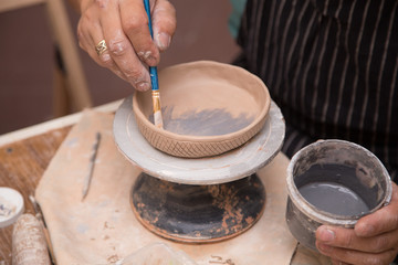 Fototapeta na wymiar Pottery workshop, raw clay, sculpting tools, glazing and painting clay pots