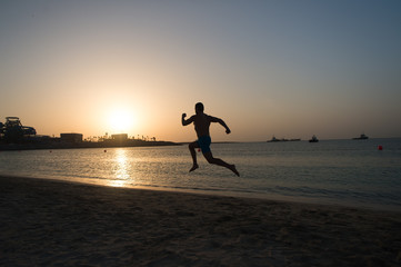 Silhouette man motion running in front of sunset sky above sea surface. Never stop. Future success depends on your efforts now. Daily motivation. Healthy lifestyle personal achievement and success