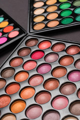 Close-up shot of eyeshadow palettes on black background
