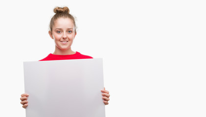 Fototapeta premium Young blonde woman holding advertising banner with a happy face standing and smiling with a confident smile showing teeth