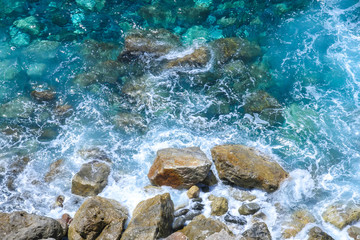 Rocks in the blue Mediterranean Sea on a bright sunny day.