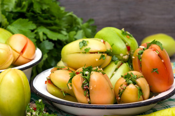 Green tomatoes stuffed with pepper and herbs in a plate.
