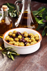 Olives. Bottle virgin olive oil and oil in a bowl with some olives