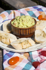 baguette slices smeared with some garlic butter with guacamole dip