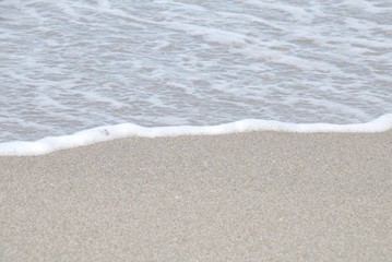 Fototapeta na wymiar Auflaufende Welle am Strand von Fehmarn