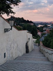 sunrise over the empty old historic stairs under the prague castle with city centre in the background