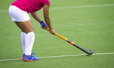 Young hockey player woman with ball in attack playing field hockey game